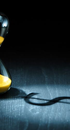 Hourglass projecting a dollar sign as shadow.