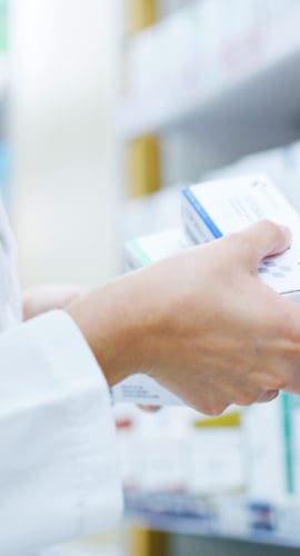 Doctor, hands or shelf with medication at pharmacy for inventory, stock or pharmaceutical service. Closeup, healthcare employee or pharmacist with box or medical product for side effect at drug store